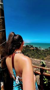 a woman is looking out at the ocean at Pousada Roane - Taíba in Taíba