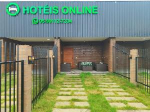 an entrance to a building with a gate and grass at Hotéis Online in Boa Vista