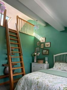 a bedroom with green walls and a staircase and a bed at Batty lodge in Cockerham