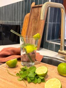 a glass of water with lime and mint on a cutting board at L'Adresse Studio Rempart sud - centre historique Eguisheim in Eguisheim
