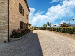 a road next to a building with flowers on the side at Apartment in a farmhouse with 2 swimming pools in Cagli