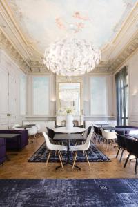 a dining room with a chandelier and tables and chairs at Hôtel C2 in Marseille