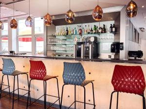 a bar with red and blue bar stools at ibis Hotel Düsseldorf Hauptbahnhof in Düsseldorf +70 photos