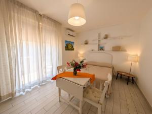 a bedroom with a bed and a table with flowers on it at Attico al Centro in Cefalù