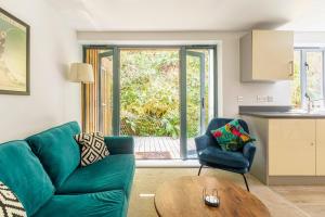 a living room with a green couch and a table at Fowey Landing in Fowey