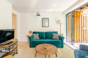a living room with a blue couch and a table at Fowey Landing in Fowey