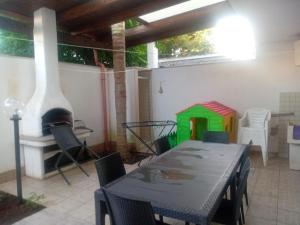a dining room with a table and a fireplace at CASA VACANZA Torre Lapillo PREMIUM in Torre Lapillo