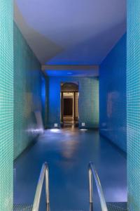 a indoor swimming pool with blue walls and stairs at Hôtel C2 in Marseille