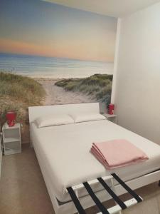a bed in a room with a painting of a beach at Baita Monte Caruso in Filiano