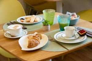 a table with plates of food and cups of coffee at G&G Bed&Breakfast in Bonorva