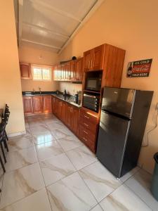 a kitchen with wooden cabinets and a stainless steel refrigerator at Casa Verde in Mbocayaty +1 photo