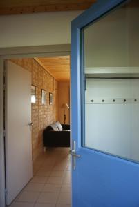 a door leading into a living room with a couch at Les Gîtes du Chênelet in Landrethun-le-Nord