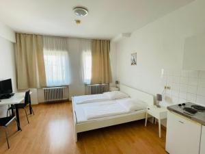 a bedroom with a bed and a desk and a table at Hotel Westend in Cologne
