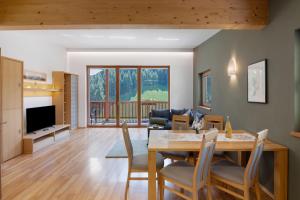 a dining room and living room with a table and chairs at Pritscheshof Ferienwohnung Balkon in Malles Venosta