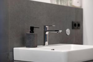 a bathroom sink with a soap dispenser on it at Pritscheshof Ferienwohnung Balkon in Malles Venosta +28 photos
