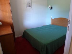 a bedroom with a bed with a green bedspread at Détendez-vous à Montflanquin 47150 in Monflanquin