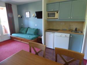 a small kitchen with a couch in the corner of a room at Détendez-vous à Montflanquin 47150 in Monflanquin