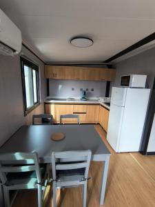a kitchen with a table and chairs and a refrigerator at Studio MAT in Herly