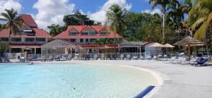a resort swimming pool with chairs and umbrellas at TI MAD vue mer in Sainte-Anne