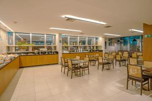 a dining room with tables and chairs in a restaurant at Naoum Hotel in Brasília
