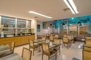 a restaurant with tables and chairs and a counter at Naoum Hotel in Brasília