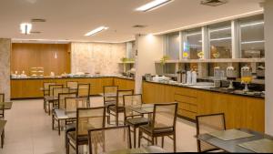 a restaurant with tables and chairs and a bar at Naoum Hotel in Brasília