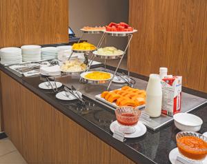 a buffet with many different types of food on a counter at Naoum Hotel in Brasília