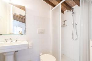 a white bathroom with a shower and a sink at Casa Bolgheri Castagno in Bolgheri +9 photos