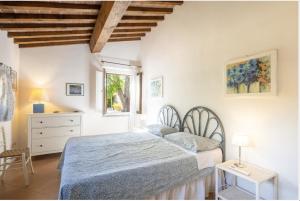 a bedroom with a bed and a dresser and a window at Casa Bolgheri Castagno in Bolgheri