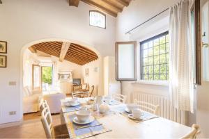 a dining room with a table and chairs and a window at Casa Bolgheri Castagno in Bolgheri