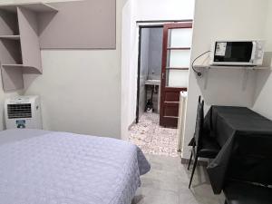 a bedroom with a bed and a television and a sink at rinconcito en floresta in Buenos Aires