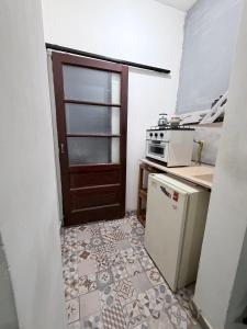 a kitchen with a door and a stove and refrigerator at rinconcito en floresta in Buenos Aires