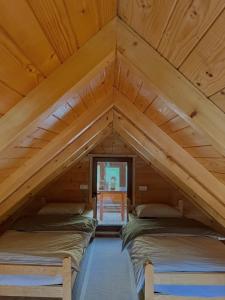 two beds in the attic of a wooden cabin at Naš raj in Berane