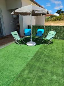 two chairs and an umbrella on a lawn at Casa do Valinho  +4 photos