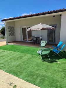 a patio with chairs and an umbrella and a table at Casa do Valinho 