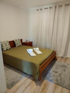 a bedroom with a bed with two towels on it at Casa do Valinho 