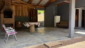 a patio with a table and a chair and a refrigerator at Recanto Salto Ano Bom in Corupá