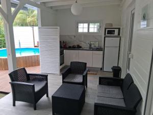 a kitchen with chairs and a kitchen with a pool at villa Kanel in Le Robert