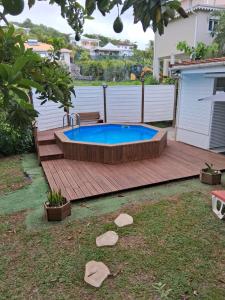 a swimming pool on a wooden deck with a wooden deck at villa Kanel in Le Robert
