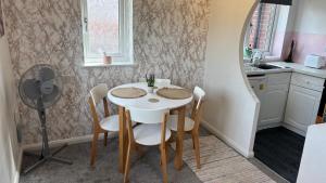a kitchen with a table and chairs and a fan at The Paddocks in Bicton