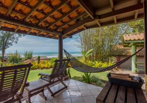 a hammock on a patio under a pergola at Village Praia do Rosa in Praia do Rosa