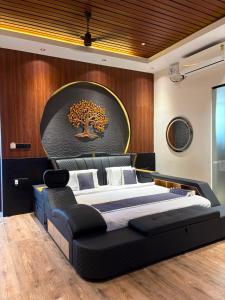 a bedroom with a large bed with a tree on the wall at Sri Vasavi Regency in Mahabalipuram +20 photos