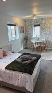 a bedroom with a bed and a dining room with a table at The Paddocks in Bicton