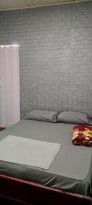 a large bed in a bedroom with a white mattress at pousada popular in Barreiras