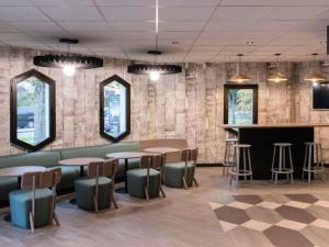 a restaurant with tables and chairs and a bar at ibis Cergy Pontoise Le Port in Cergy