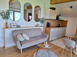 a living room with a couch and two mirrors at Apartament Polana No 24 in Bańska Wyżna