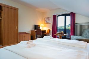 a hotel room with two beds and a window at Alembra - Hotel zur Moselbrücke in Schweich