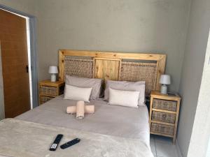 a bedroom with a bed with two remote controls on it at Nkandla Yethu Guest House in Nelspruit