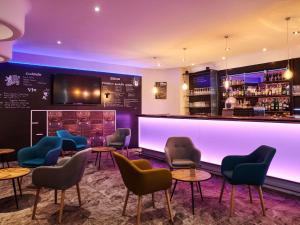 a bar with chairs and tables and a counter at Mercure Rennes Centre Gare in Rennes