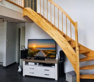 a living room with a television and a staircase at Ferienhaus Klabautermann 53 - Nordhorn in Nordhorn